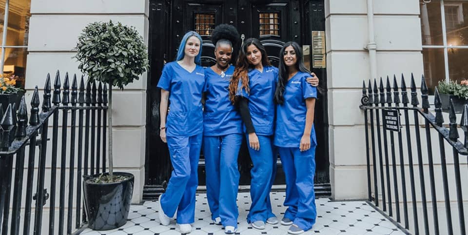 Sofwave ultrasound skin lifting London - four nurses in blue scrubs outside a Georgian Four nurses in blue scrubs outside a Georgian clinic entrance, Sofwave ultrasound skin lifting London